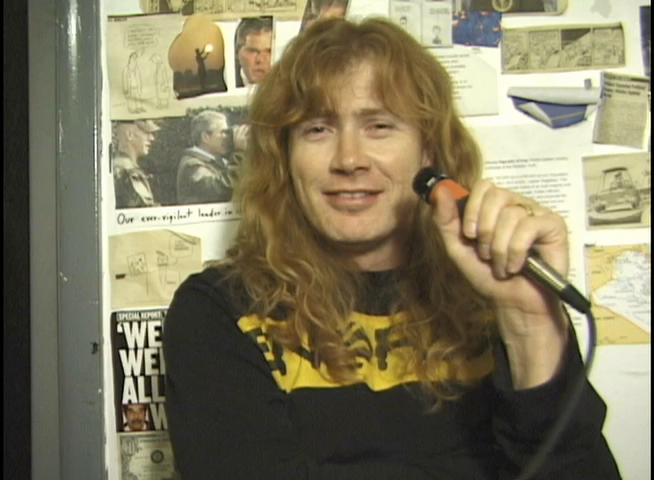 Dave Mustaine smiling with a microphone during the Rocks Vault interview.